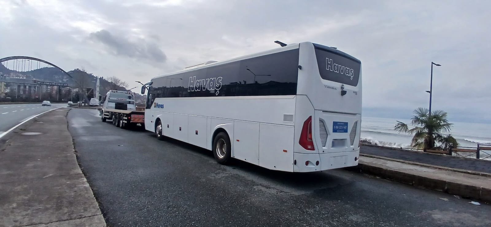 Lowbed üzerinde taşınan beyaz yolcu otobüsü